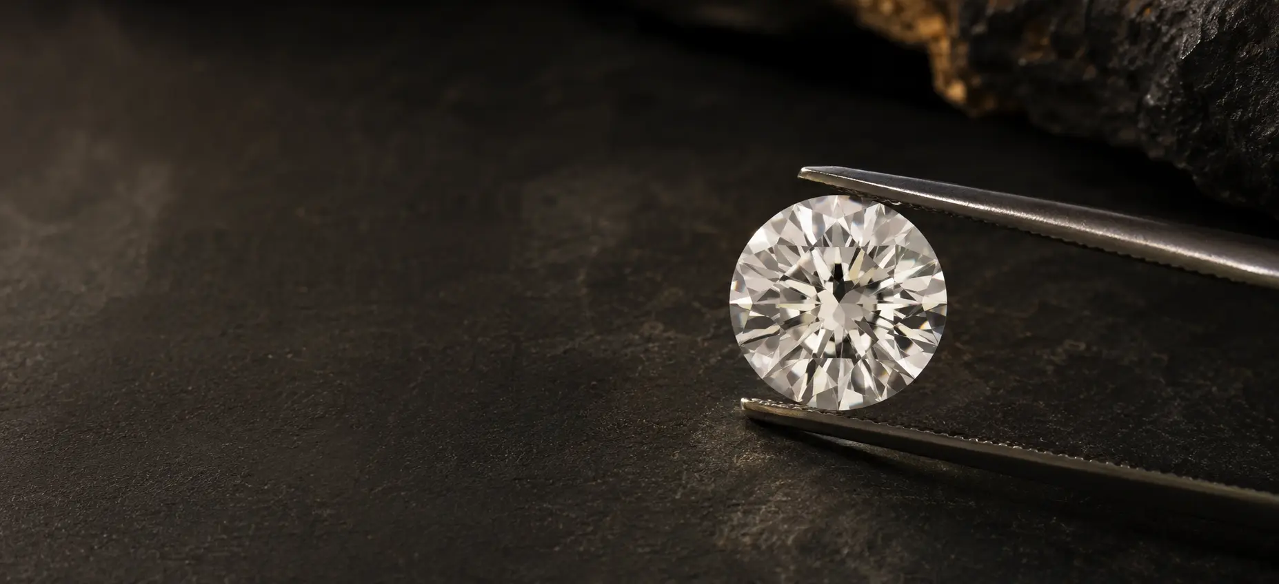 A natural diamond held in jewellers tweezers
